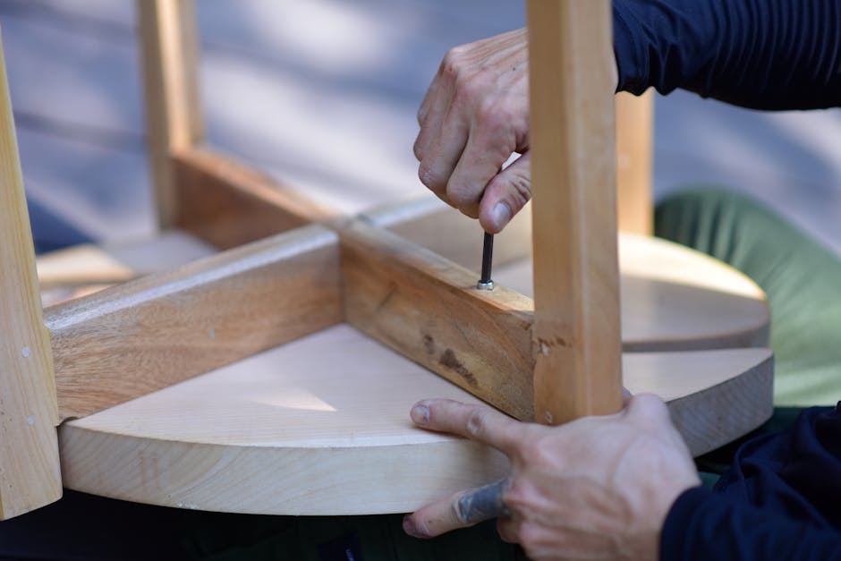 Hands assembling a wooden stool, highlighting craftsmanship and DIY spirit.