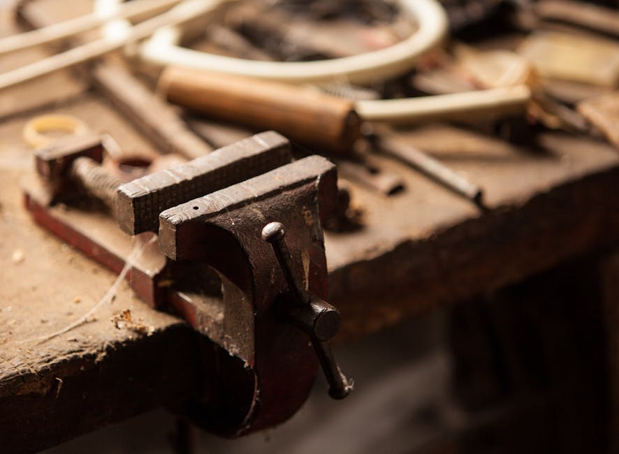 A detailed view of a workshop table with tools highlighting a metal clamp and wood textures.
