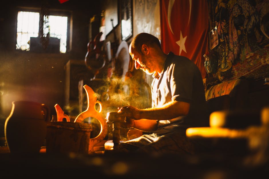 Turkish potter shaping clay in a sunlit workshop, creating beautiful pottery.
