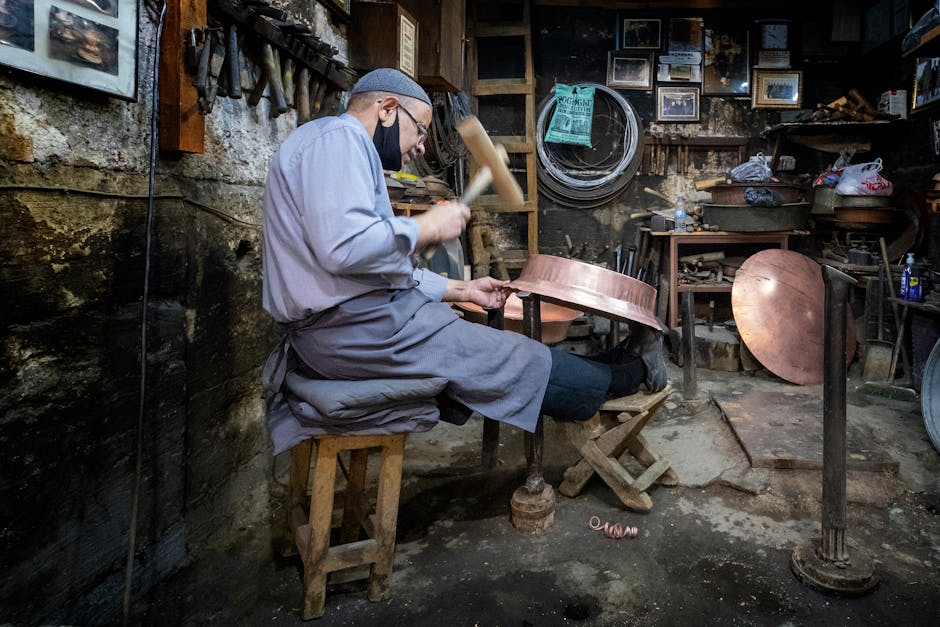 A skilled artisan working on copperware in a traditional workshop in Şanlıurfa, Türkiye.