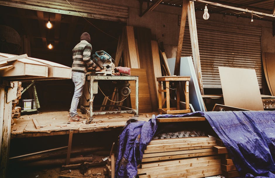 Carpenter focused on woodworking inside a cozy, rustic workshop.